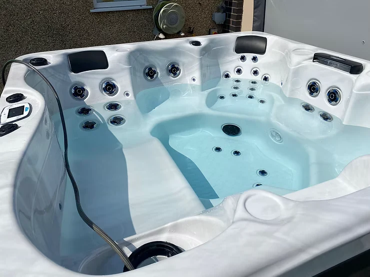 White hot tub being filled with water during maintenance.